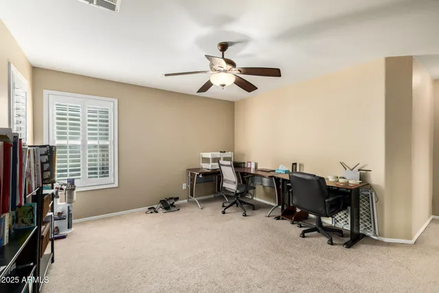 a view of a workspace with furniture and a window