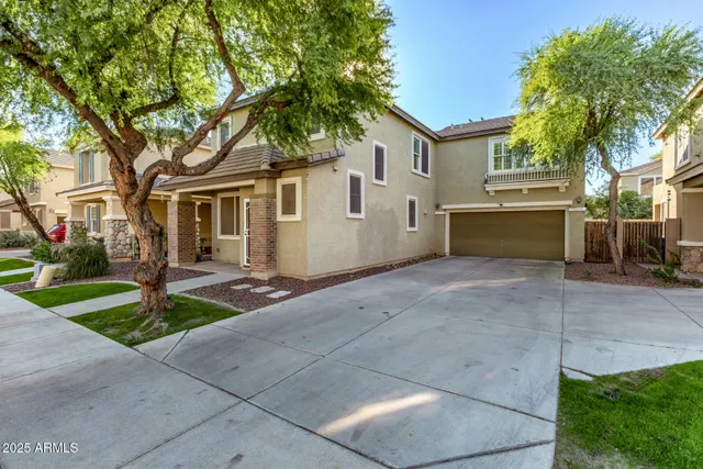 a front view of a house with garage and plants