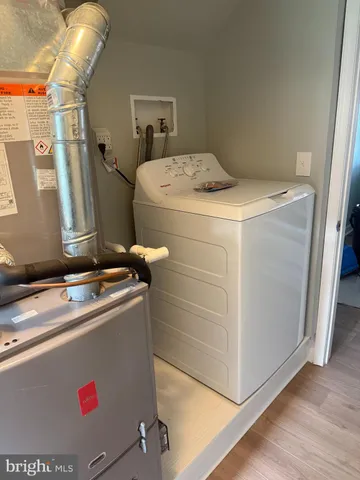 a room with water heater refrigerator washer and dryer