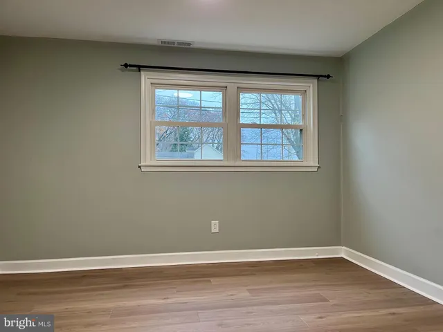 a view of a big room with wooden floor and windows
