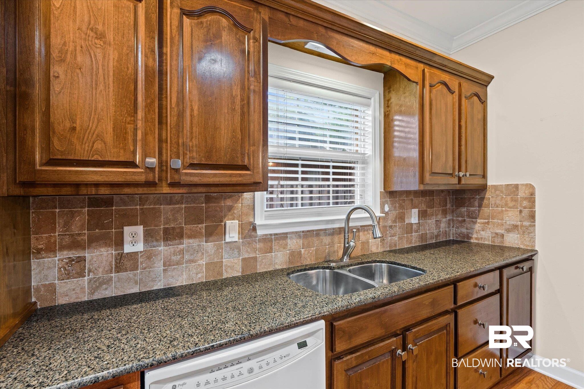 1003 Weatherby Street South Saraland, AL 36571 - Photo 17 of 31 Kitchen with dishwasher, dark stone counters, wood finish cabinets, crown molding, and decorative backsplash