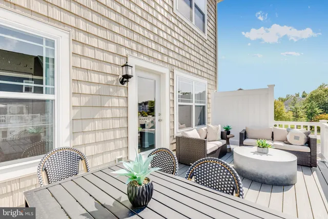 a view of a patio with couches table and chairs and potted plants