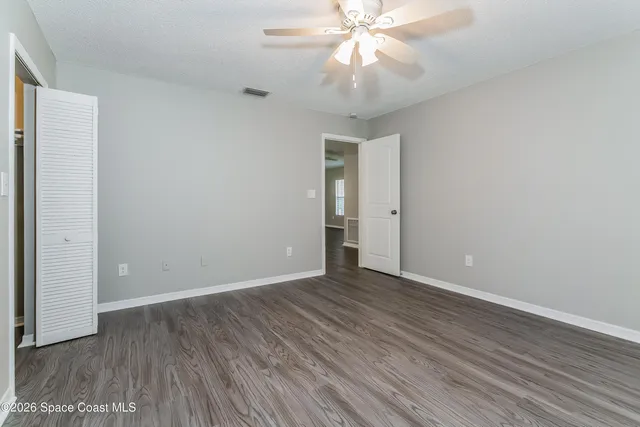 a view of an empty room with wooden floor