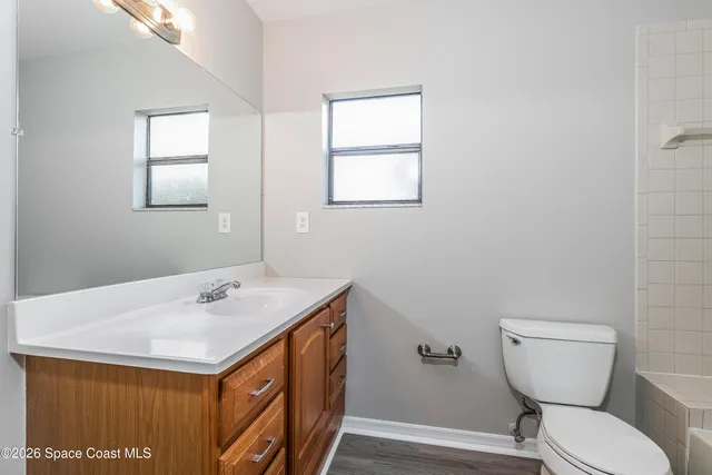 a bathroom with a sink a toilet and a window