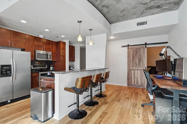 a kitchen with stainless steel appliances granite countertop a refrigerator and a stove