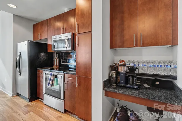 a kitchen with granite countertop a refrigerator stove and sink