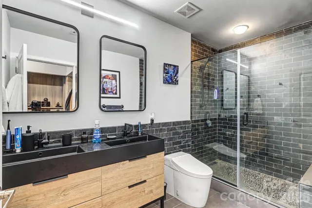 a bathroom with a double vanity sink toilet and mirror