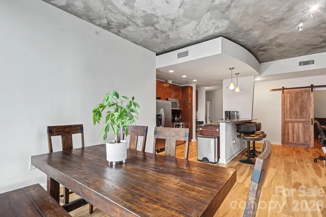 a kitchen with a refrigerator and a wooden floor