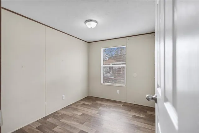 a view of an empty room with closet and a window