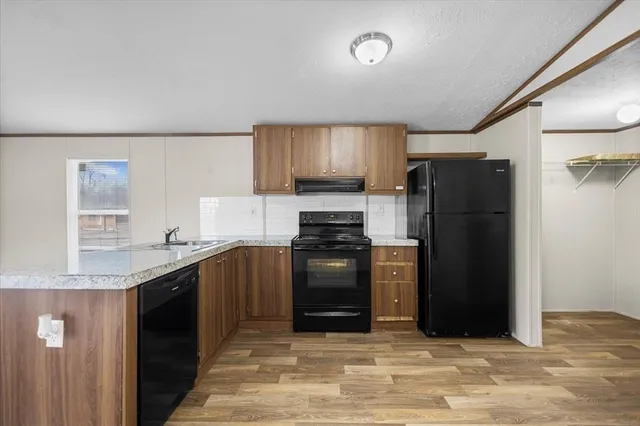 a kitchen with granite countertop a refrigerator stove and sink