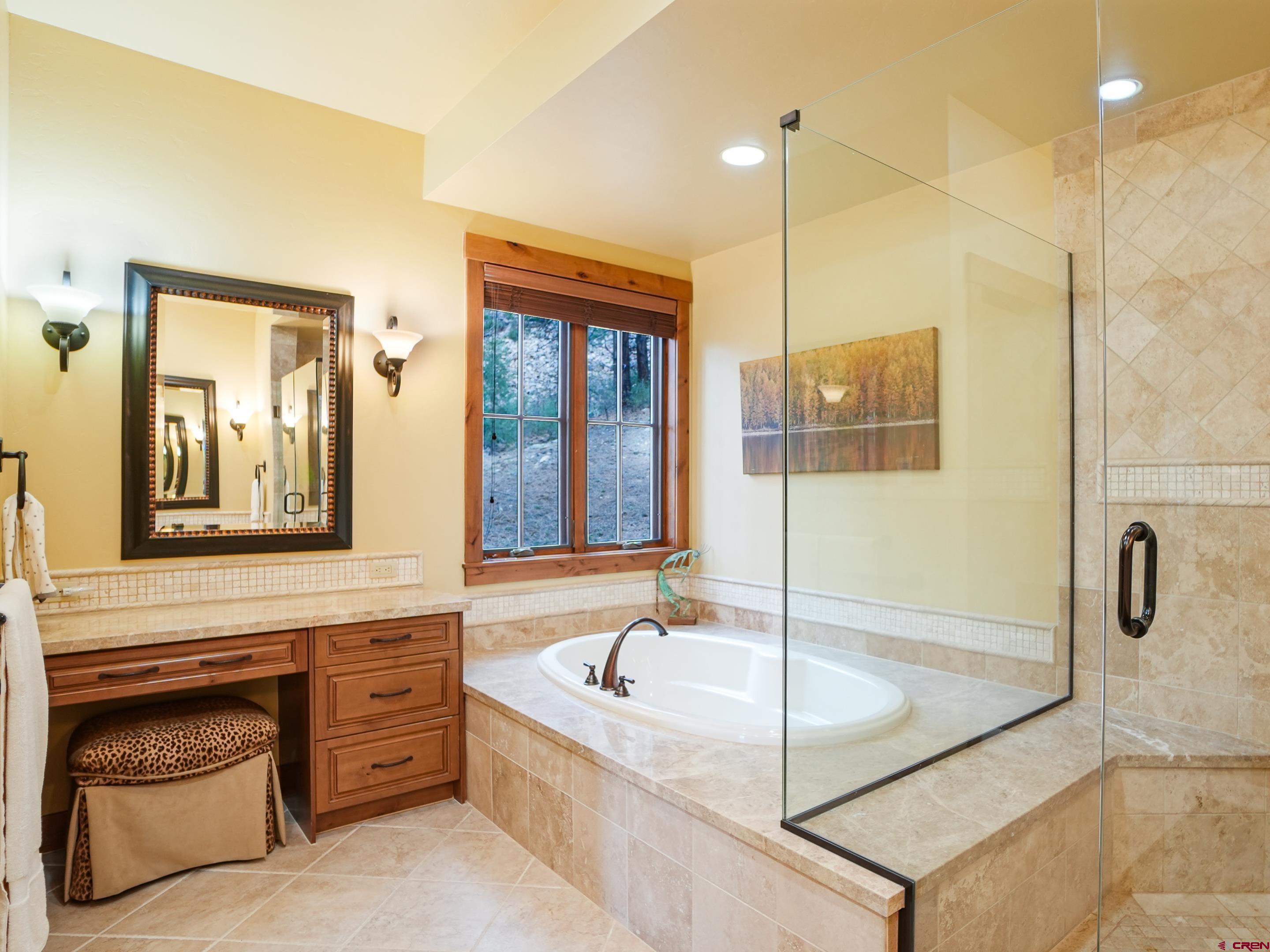 77 Ambush Canyon Durango, CO 81301 - Photo 16 of 25 a bathroom with a granite countertop tub shower and mirror