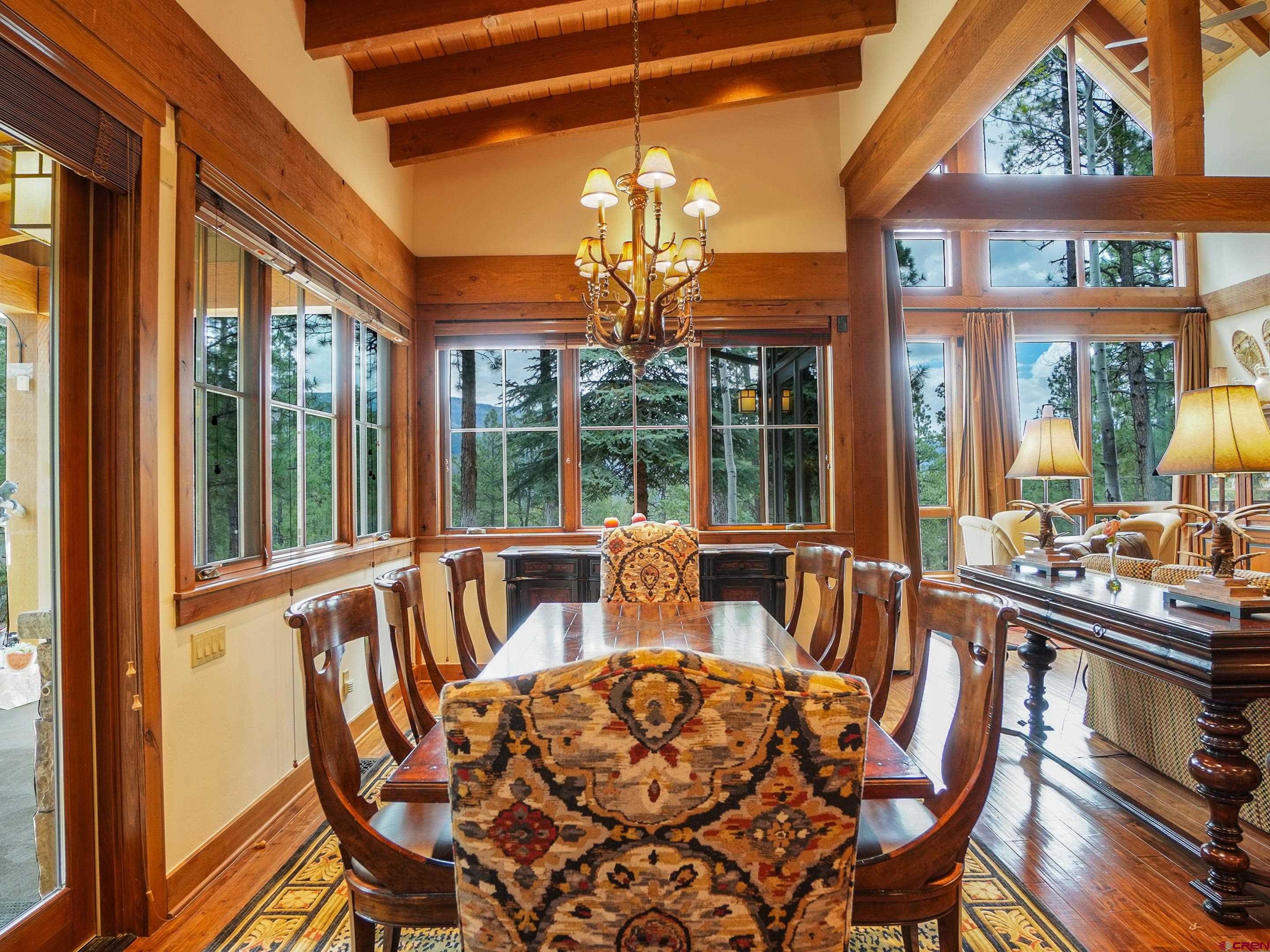 77 Ambush Canyon Durango, CO 81301 - Photo 3 of 25 a view of a dining room with furniture a chandelier and large windows