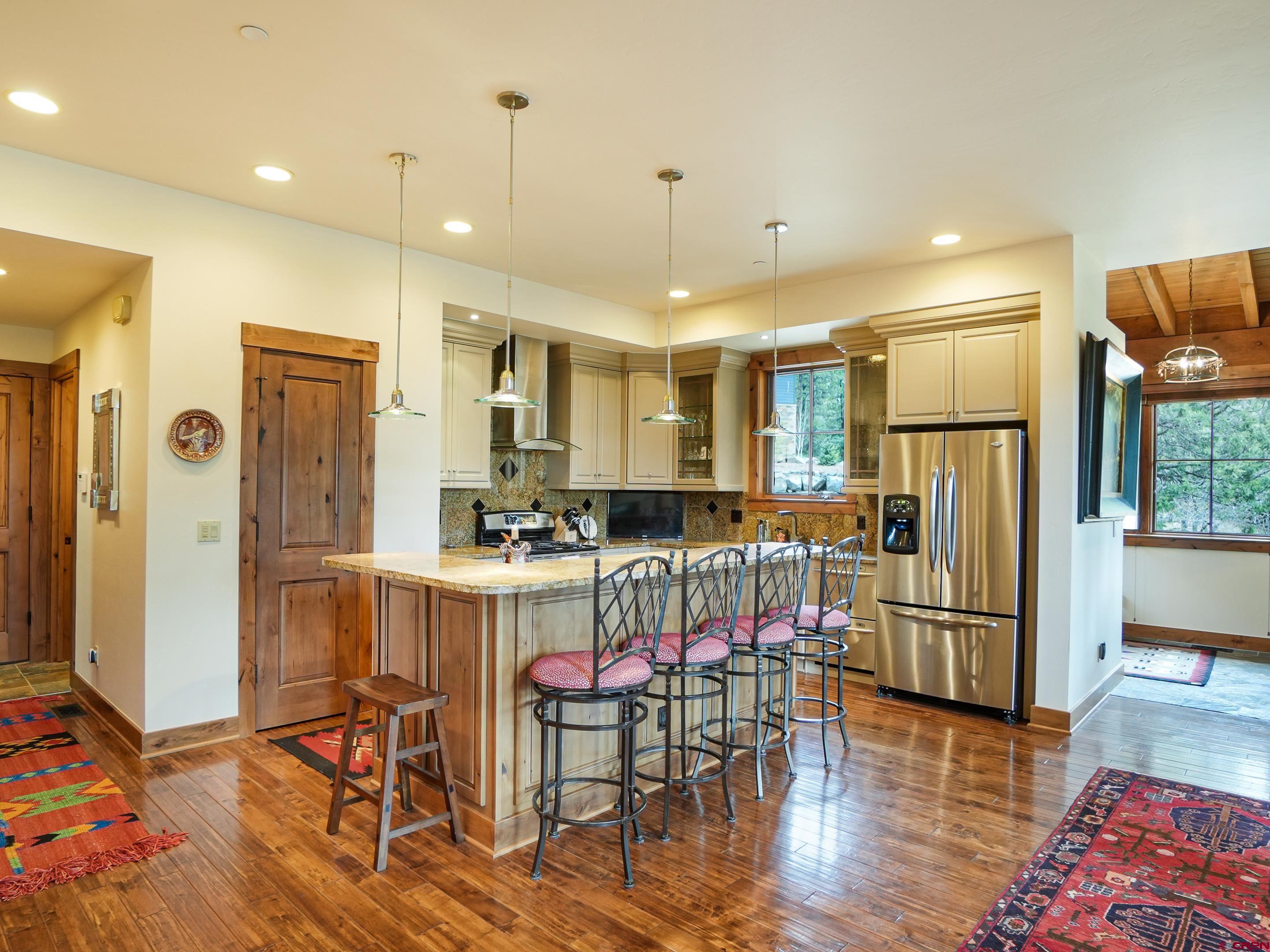 77 Ambush Canyon Durango, CO 81301 - Photo 5 of 25 a kitchen with stainless steel appliances granite countertop a dining table chairs refrigerator and sink