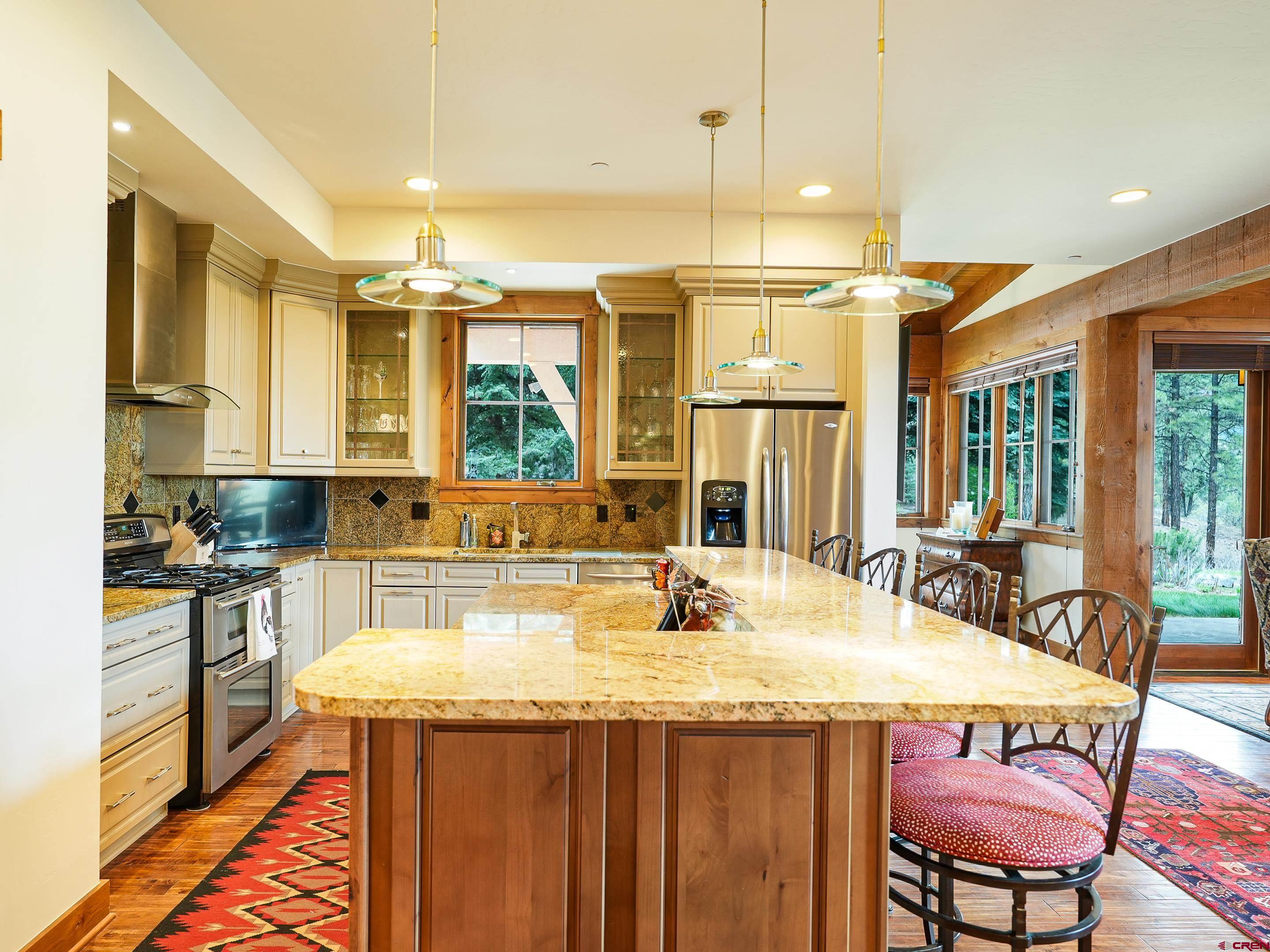 77 Ambush Canyon Durango, CO 81301 - Photo 6 of 25 a kitchen with a stove a sink a dining table and chairs