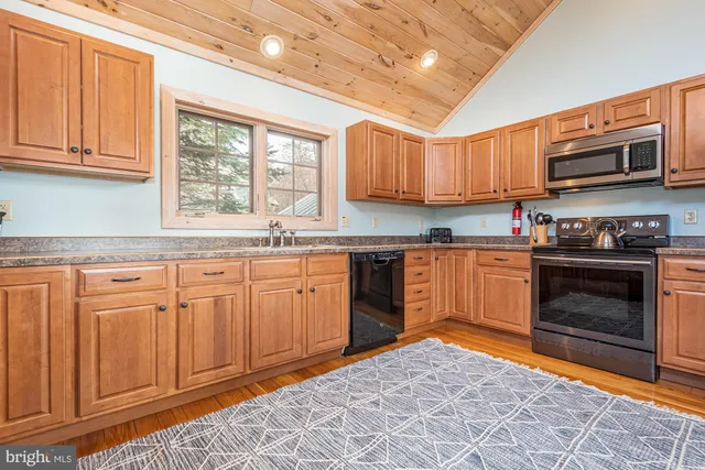 a dining room with wooden floor a chandelier a wooden table and chairs