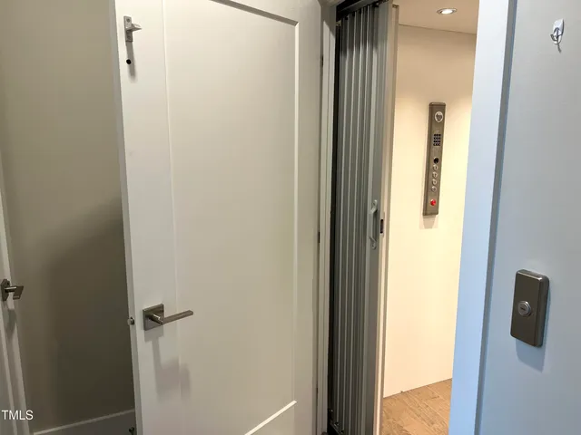 a large white kitchen with lots of counter space wooden floor and stainless steel appliances