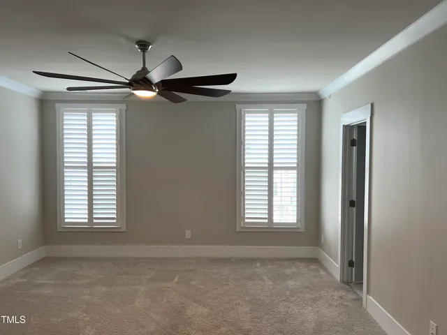 en empty room with windows and ceiling fan