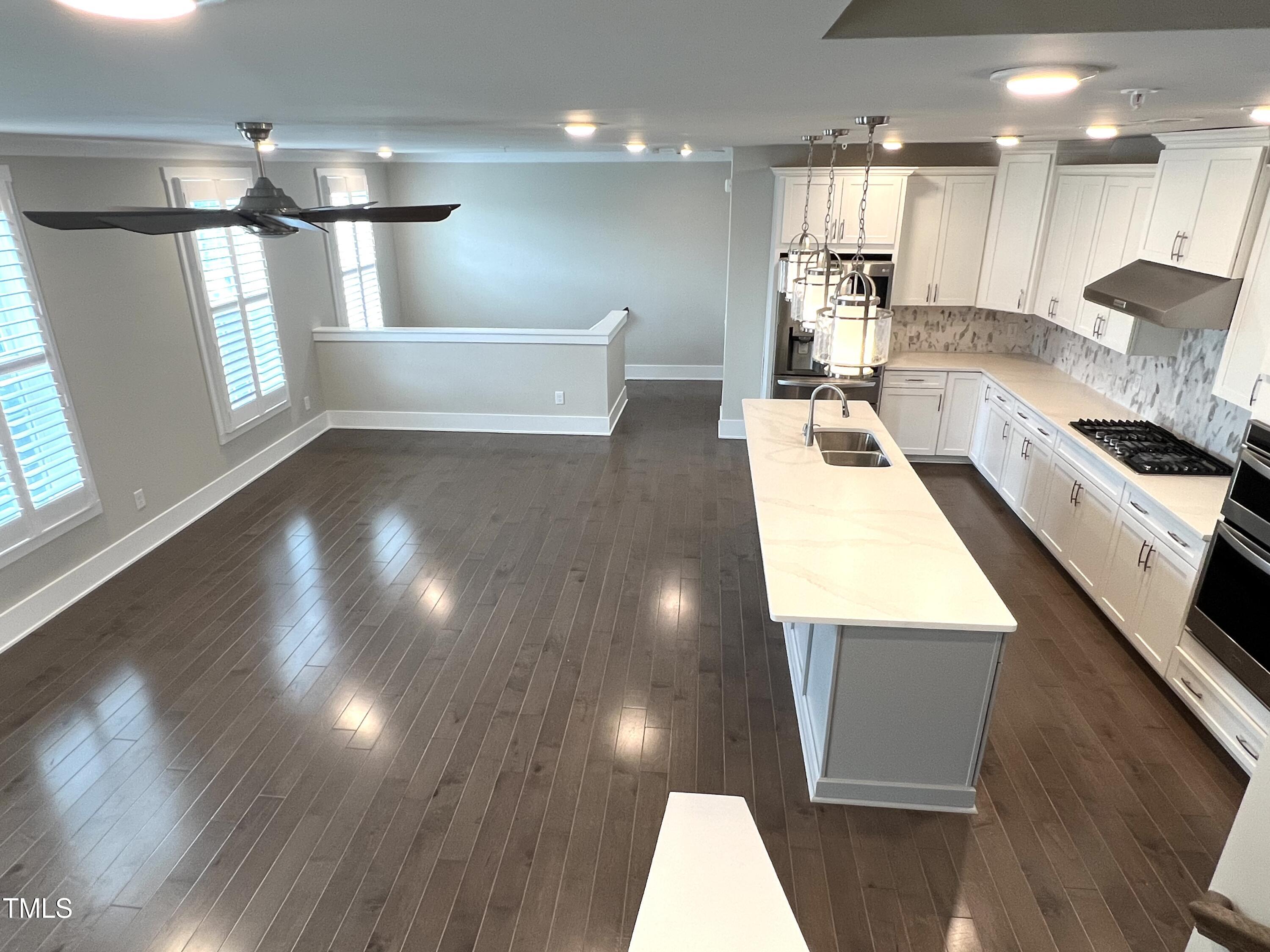 10530 Sablewood Drive, Unit 113 Raleigh, NC 27617 - Photo 4 of 61 a large white kitchen with lots of counter space wooden floor and stainless steel appliances