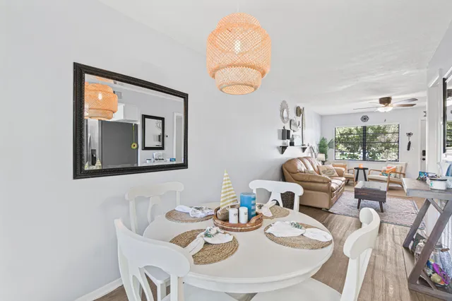 a dining room with furniture a large window and wooden floor