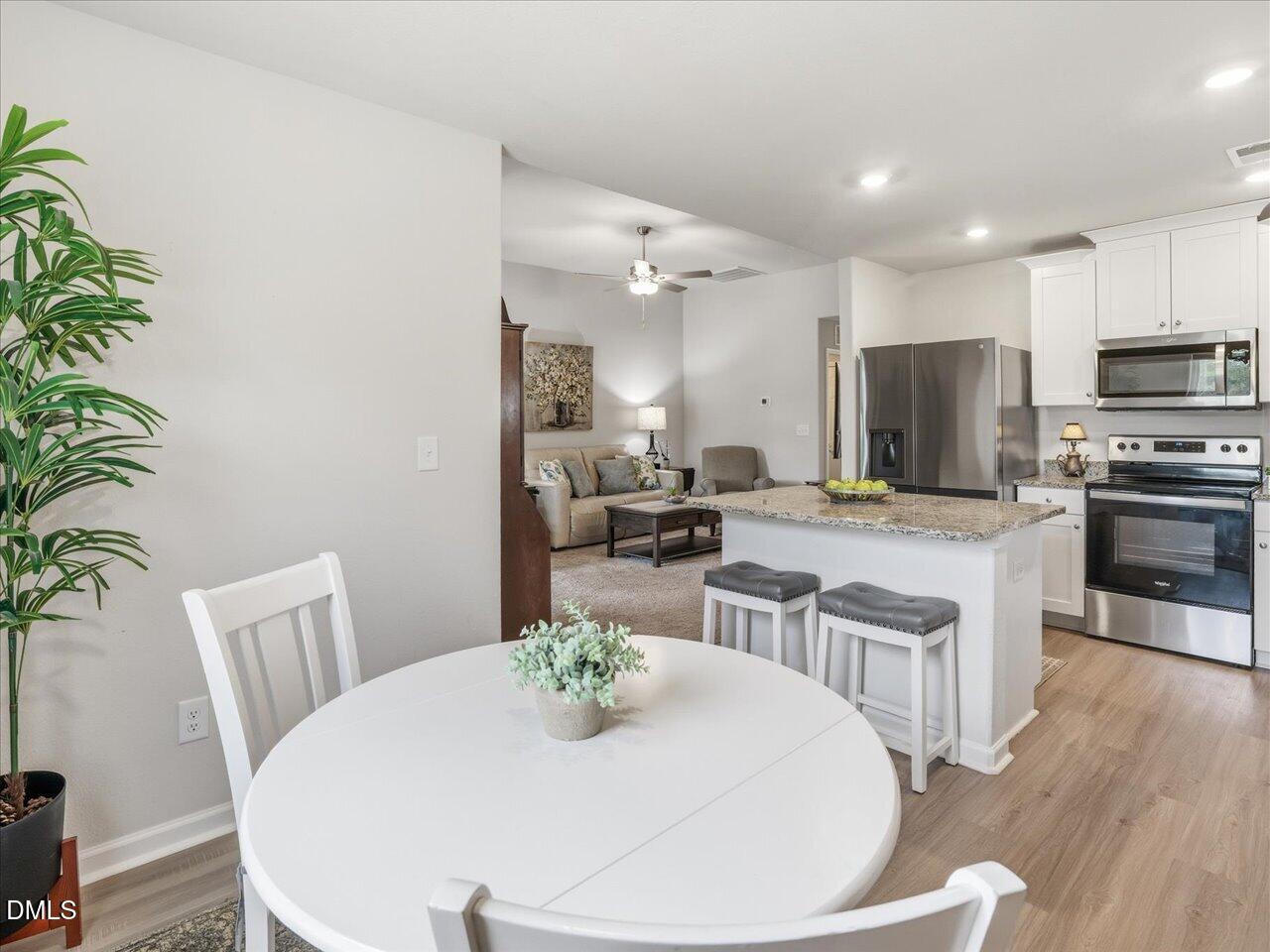 90 Barnsley Road Angier, NC 27501 - Photo 18 of 40 a kitchen with kitchen island a stove a dining table and chairs