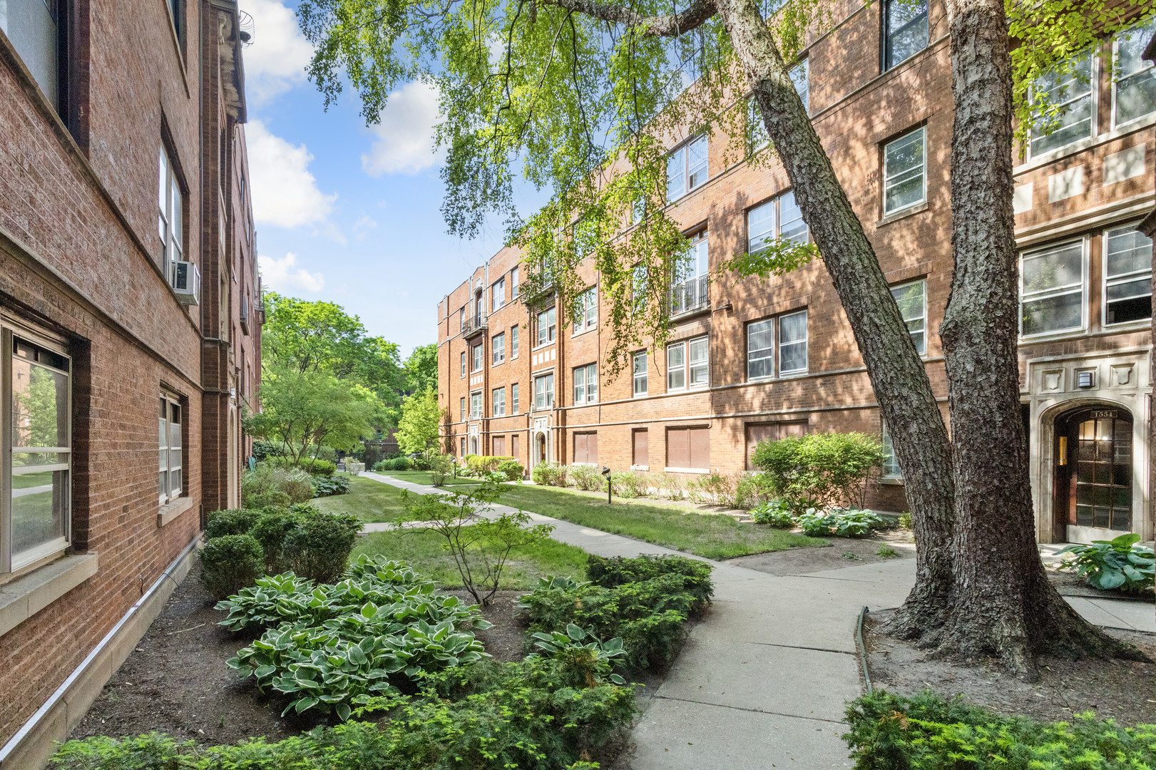 1554 West Juneway Terrace, Unit 3R Chicago, IL 60626 - Photo 1 of 8 a view of a building with a garden