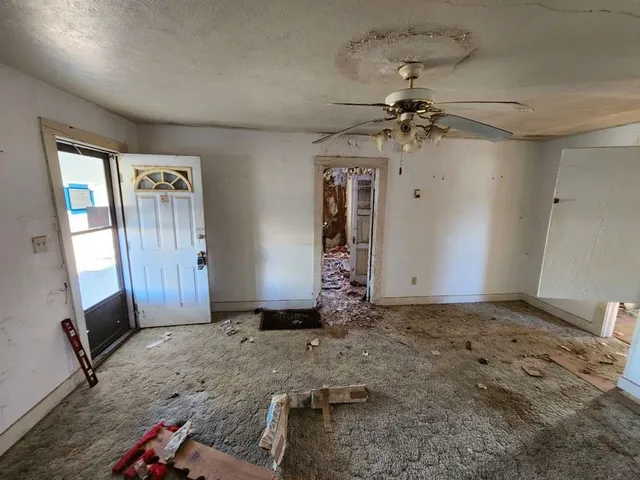 a view of a livingroom with a ceiling fan & entryway