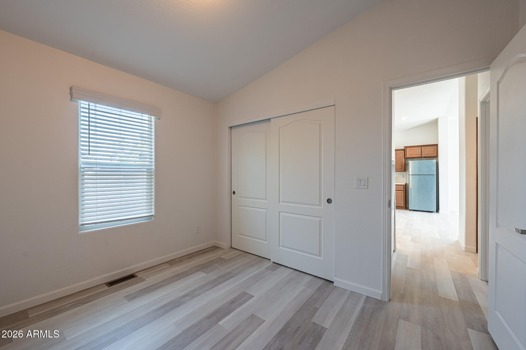 1250 East Bell Road, Unit 11 Phoenix, AZ 85022 - Photo 17 of 24 a view of an empty room with wooden floor and a window