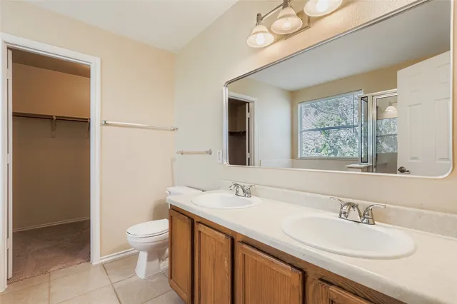 a bathroom with a granite countertop sink mirror vanity and toilet