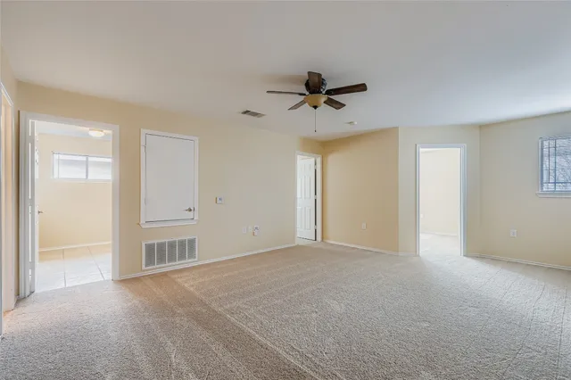 a view of a livingroom with a ceiling fan & entryway