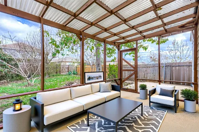 a living room with patio furniture and a backyard