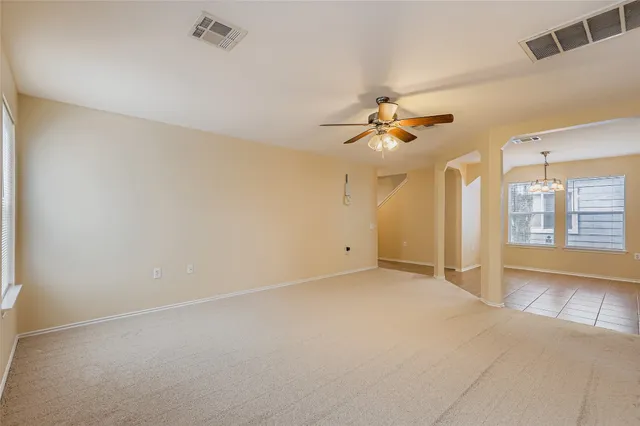 an empty room with a ceiling fan and a large window