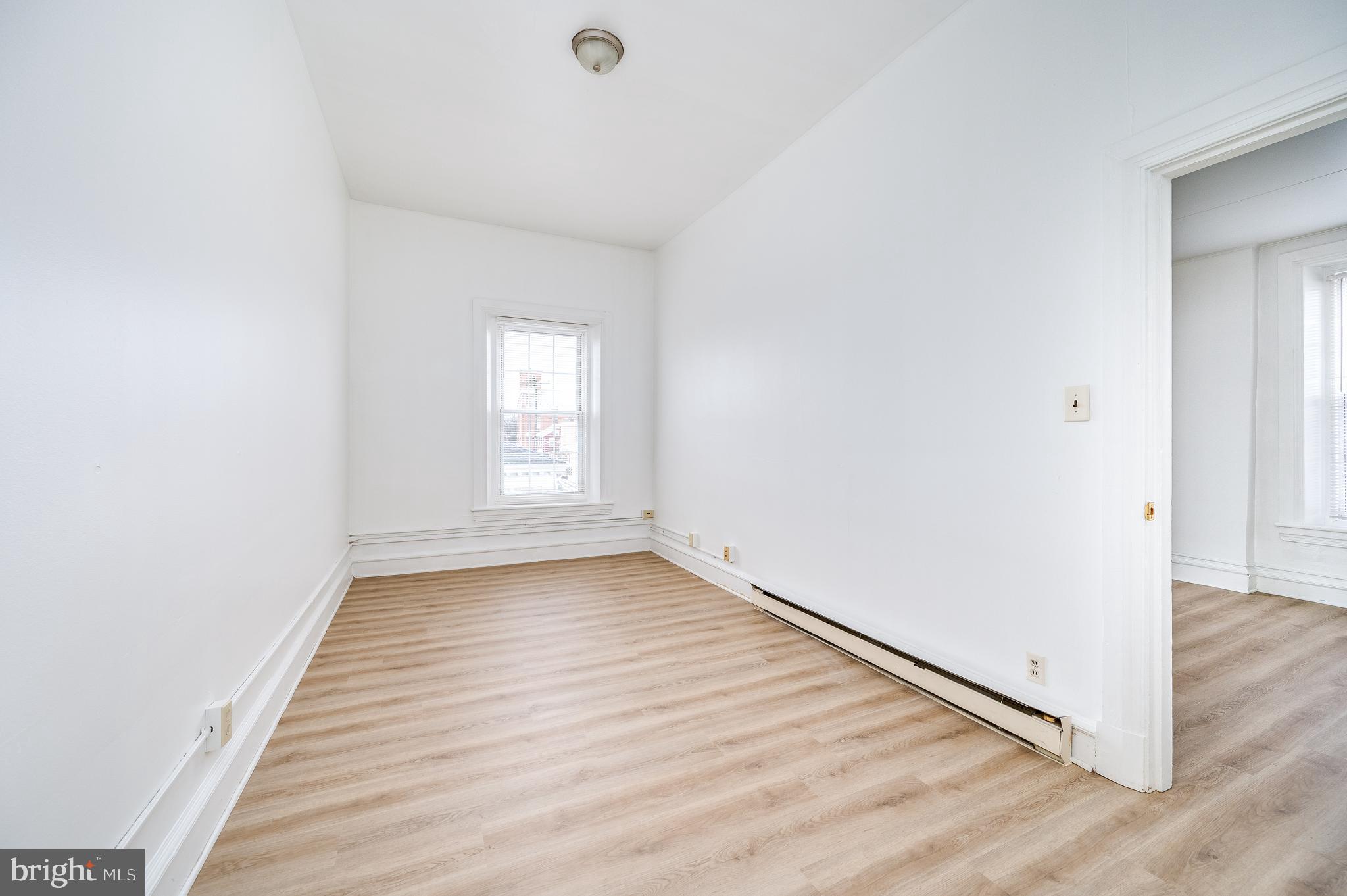 302-4 West Main Street Kutztown, PA 19530 - Photo 15 of 37 an empty room with wooden floor and window