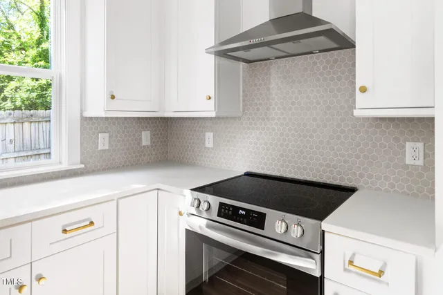 a kitchen with a stove and white cabinets