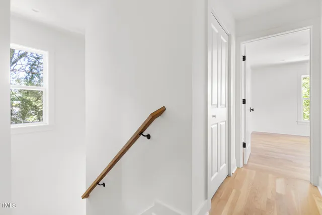 a view of a hallway with wooden floor and staircase