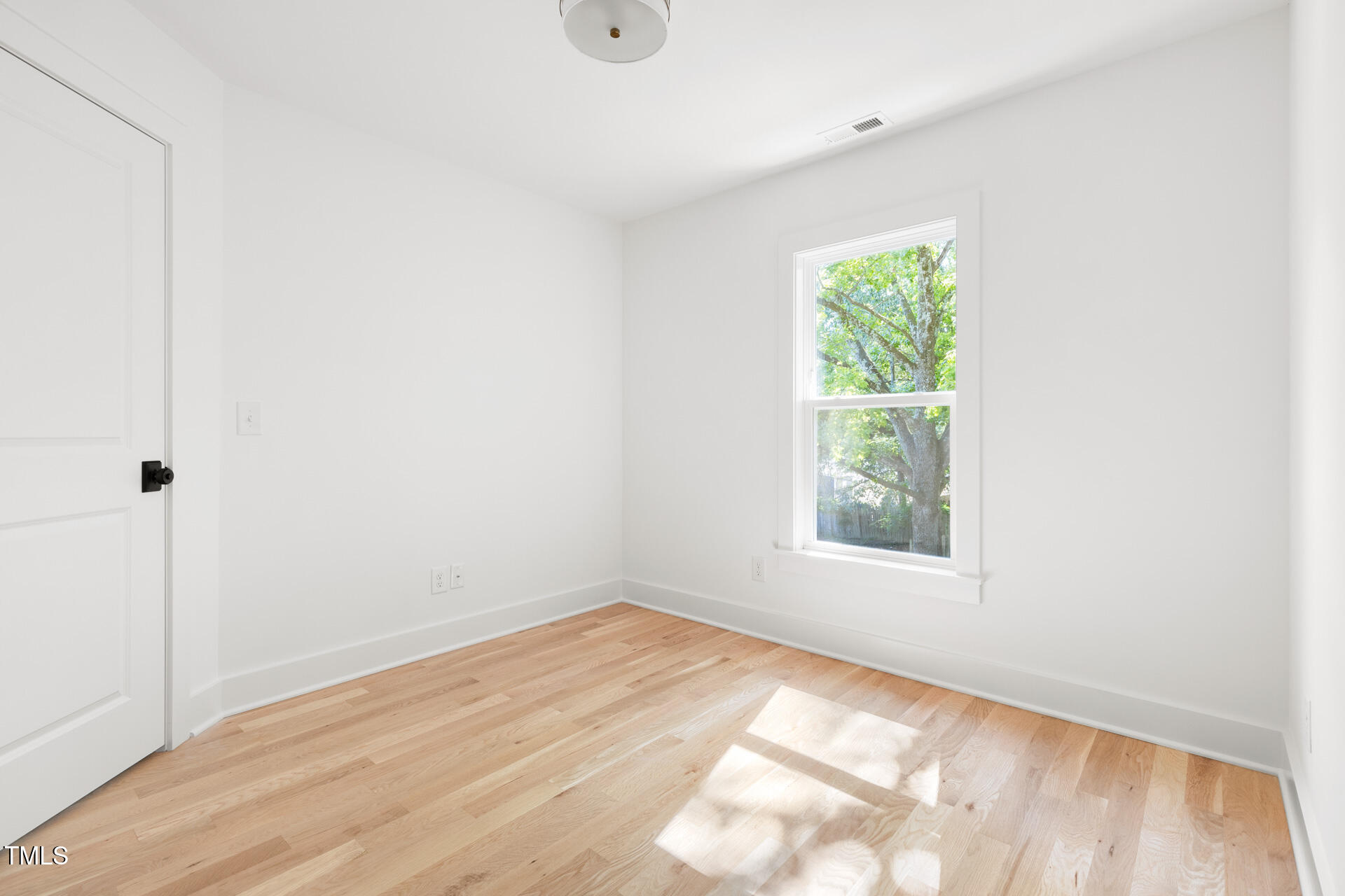 407 B Edward Street Durham, NC 27701 - Photo 27 of 39 an empty room with wooden floor and windows