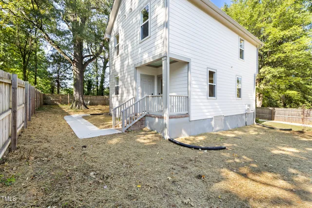 a view of a house with backyard and trees