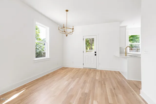 a view of empty room with window and wooden floor