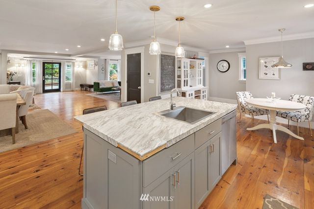 a large kitchen with kitchen island a sink table and chairs