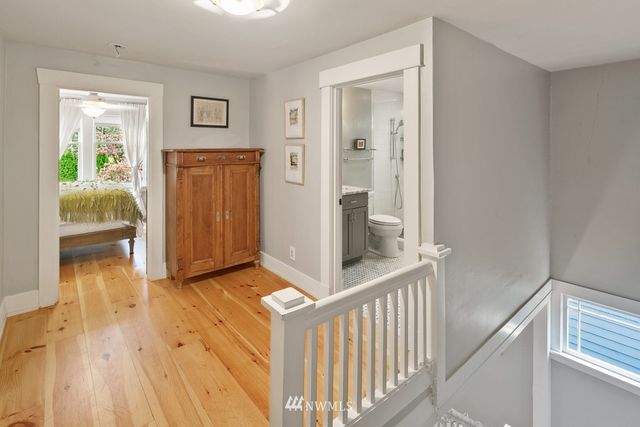 a view of hallway with wooden floor and livingroom