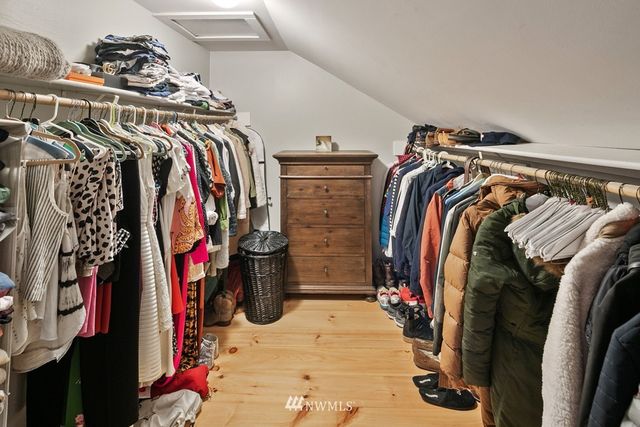 a view of walk in closet with clothes and shoes