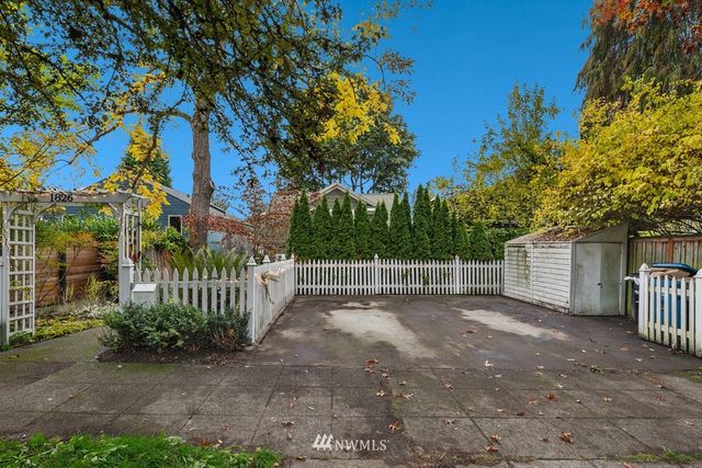 a view of a yard with plants and wooden fence