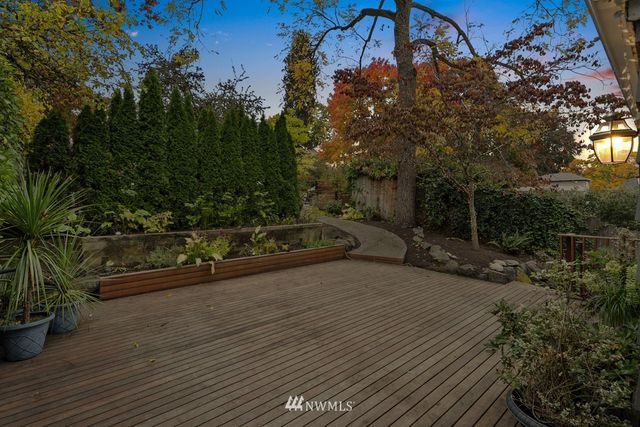 a view of a street with potted plants and large trees