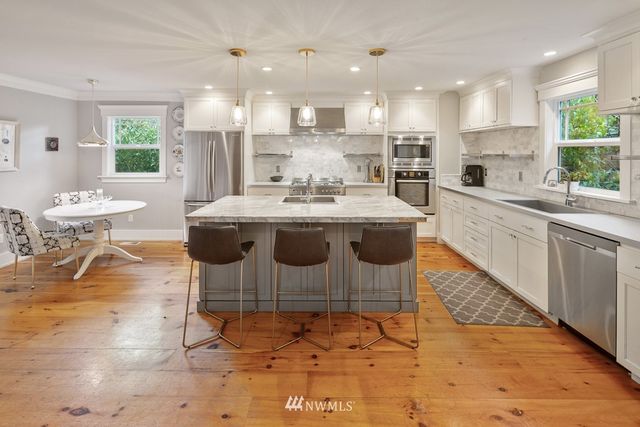 a kitchen with stainless steel appliances kitchen island granite countertop a sink and cabinets