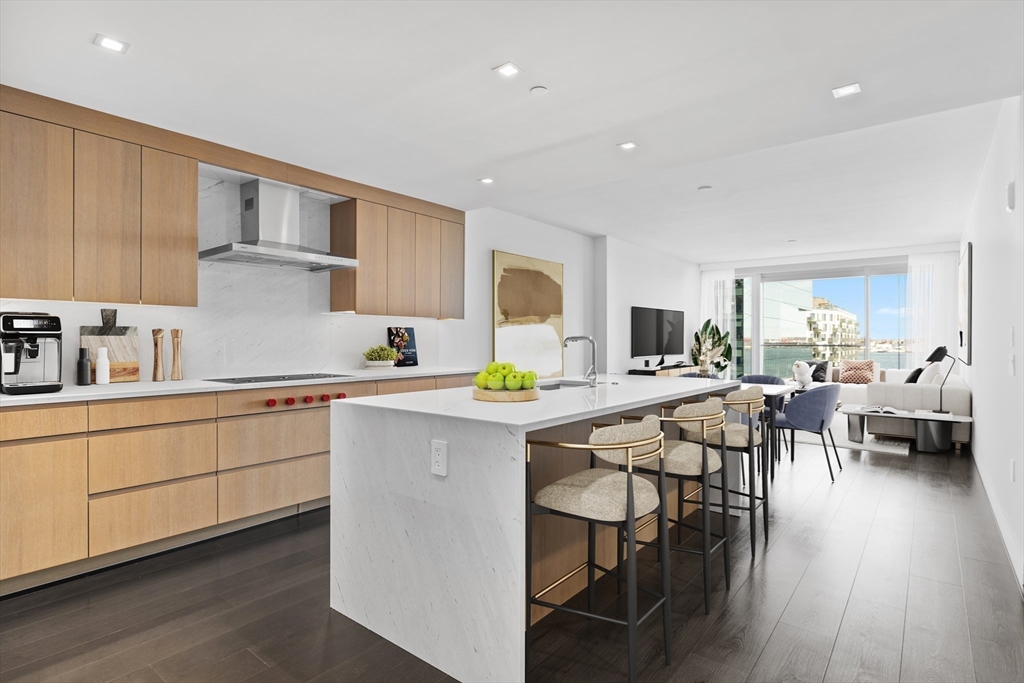 150 Seaport Boulevard, Unit 7D Boston, MA 02210 - Photo 2 of 21 a kitchen with a table chairs refrigerator and cabinets