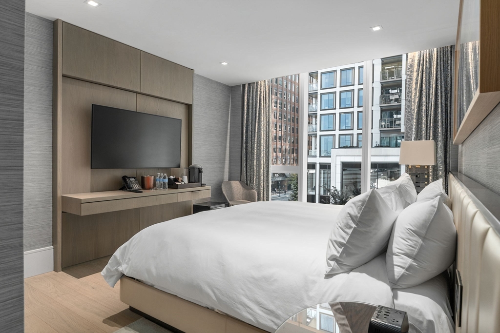 150 Seaport Boulevard, Unit 7D Boston, MA 02210 - Photo 21 of 21 a bedroom with a large bed and a flat tv screen on dresser