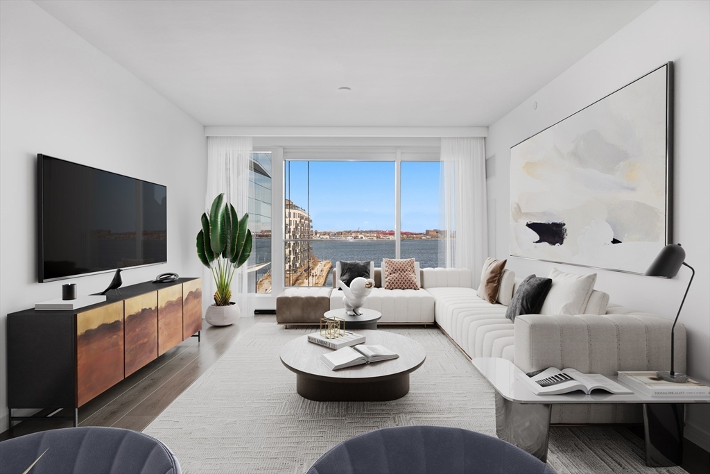 150 Seaport Boulevard, Unit 7D Boston, MA 02210 - Photo 3 of 21 a living room with furniture and a flat screen tv