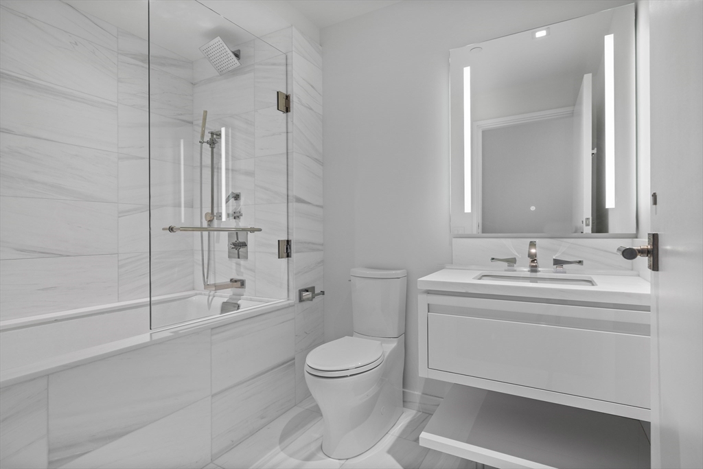 150 Seaport Boulevard, Unit 7D Boston, MA 02210 - Photo 6 of 21 a bathroom with a toilet sink and shower