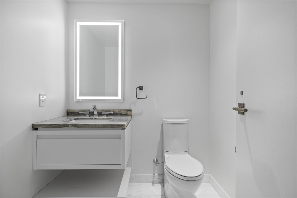 150 Seaport Boulevard, Unit 7D Boston, MA 02210 - Photo 8 of 21 a bathroom with a granite countertop toilet and a sink