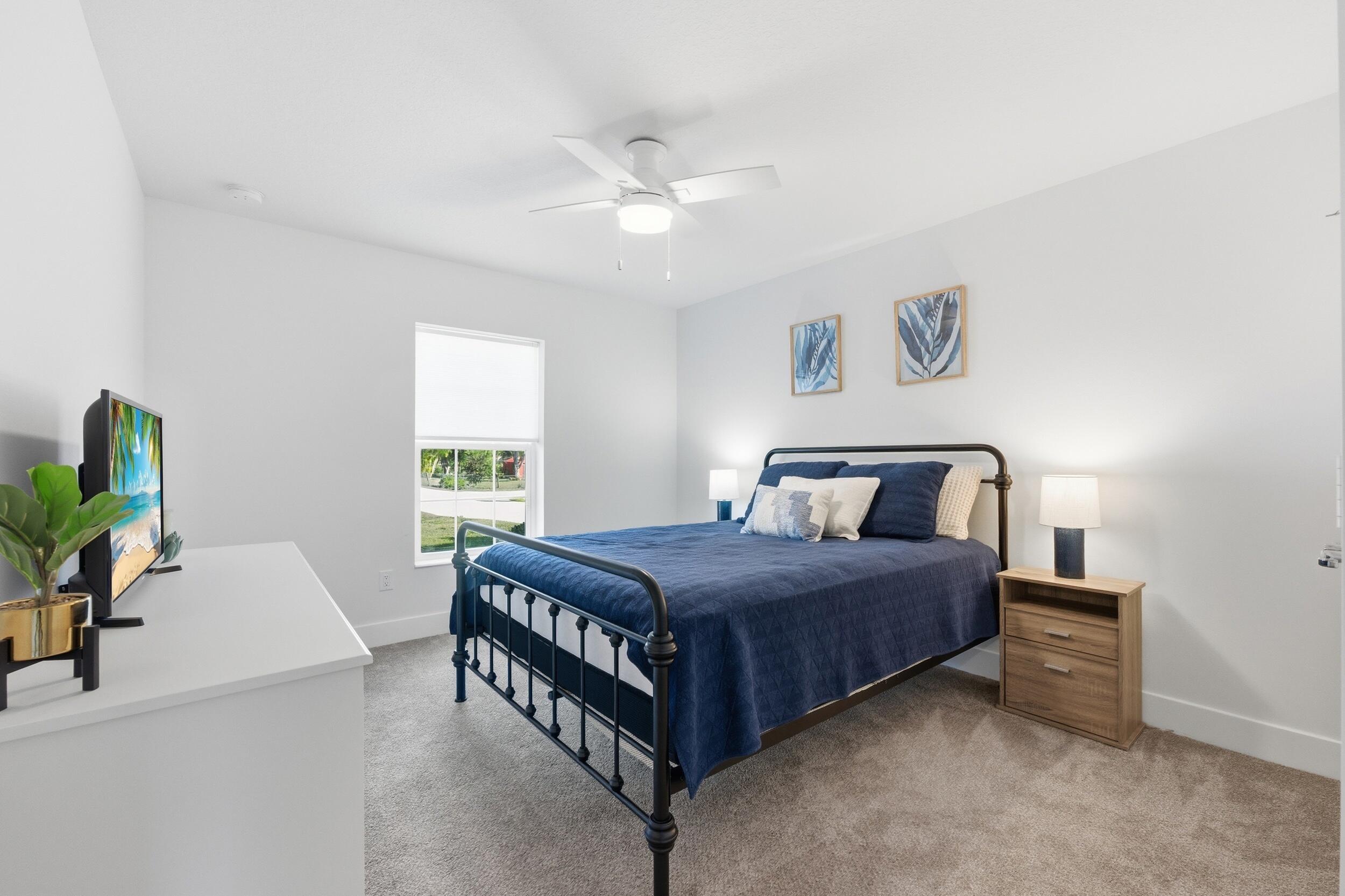 18932 42nd Road North The Acreage, FL 33470 - Photo 8 of 45 a bedroom with a bed and a chandelier