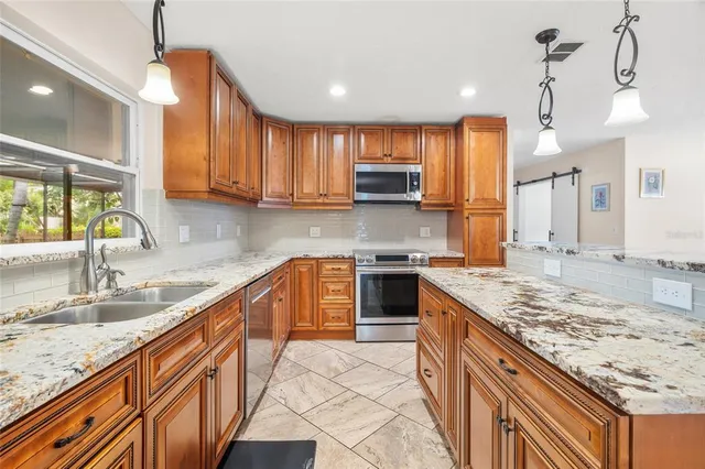 a kitchen with stainless steel appliances granite countertop a sink stove and cabinets